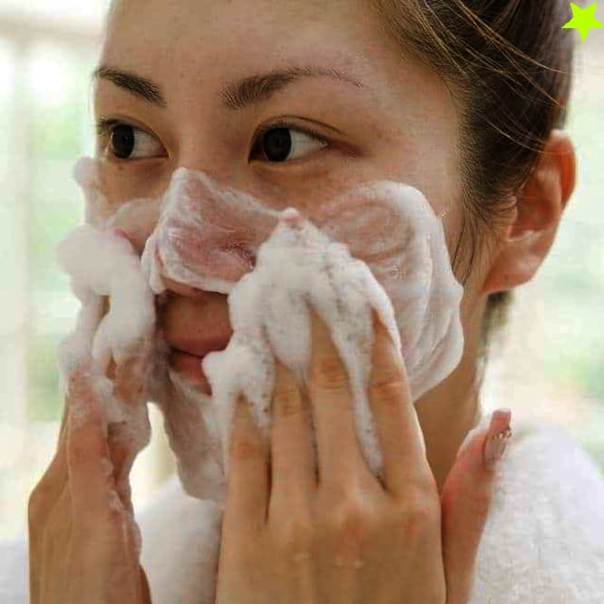 إمرأة تقوم بغسل وجهها بغسول
